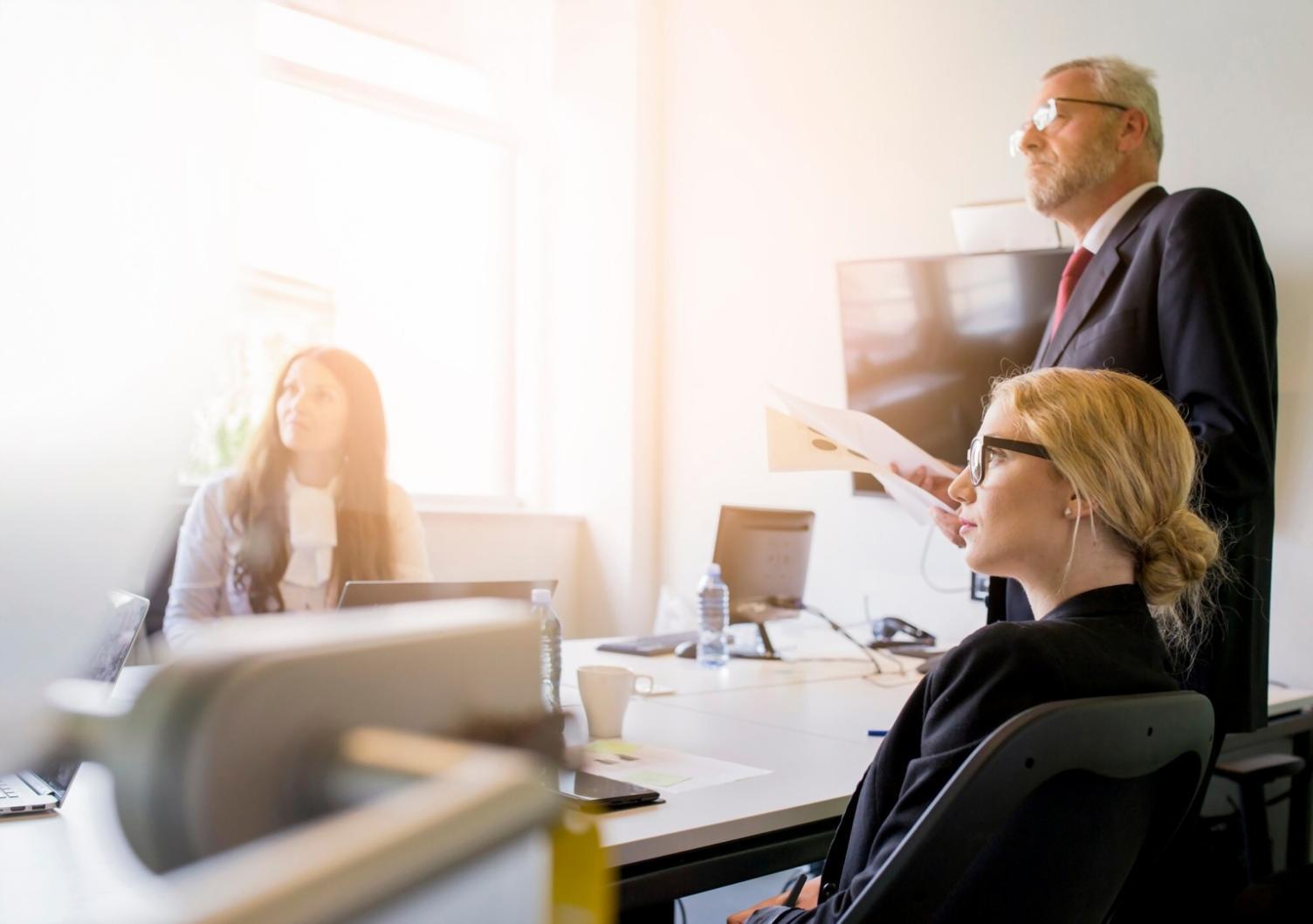 Professionnels travaillant ensemble sur l'analyse de modèles financiers dans un environnement collaboratif